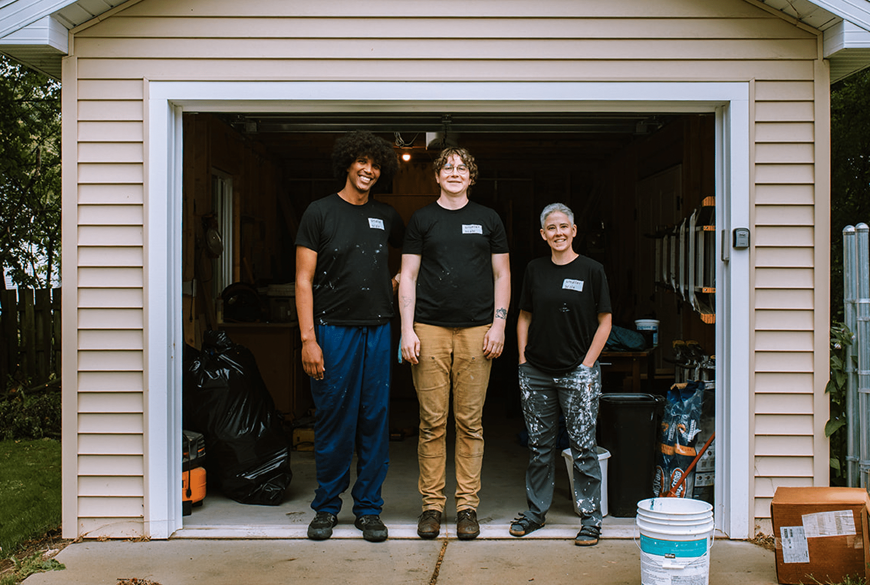 Smaller Scale Handyperson services team pictured in front of their garage workspace.